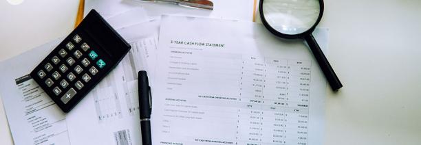 Imatge de documents, un bolígraf i una lupa